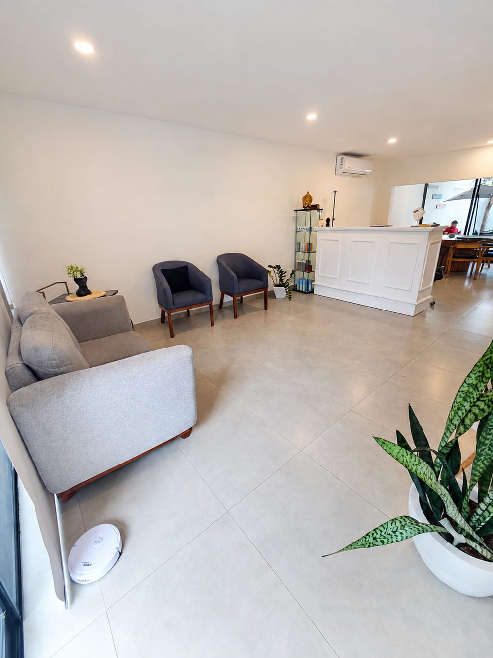 Reception desk and waiting sofas in a bright tiled room